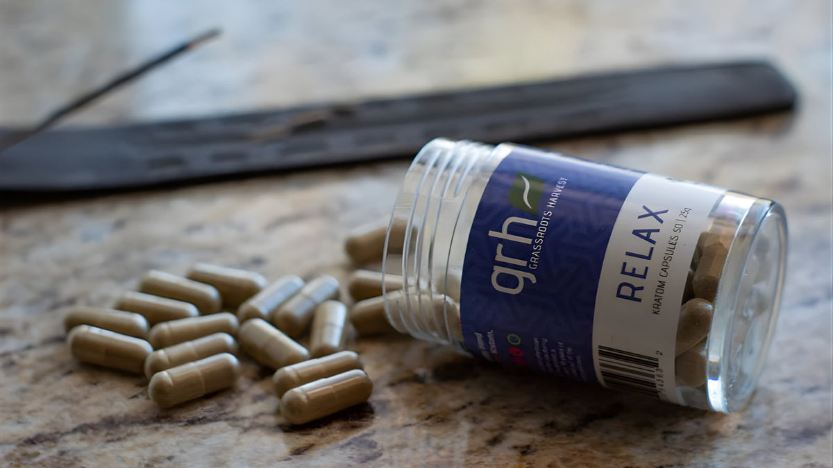 GRH red vein kratom powder and capsules on a clean surface with batch labeling