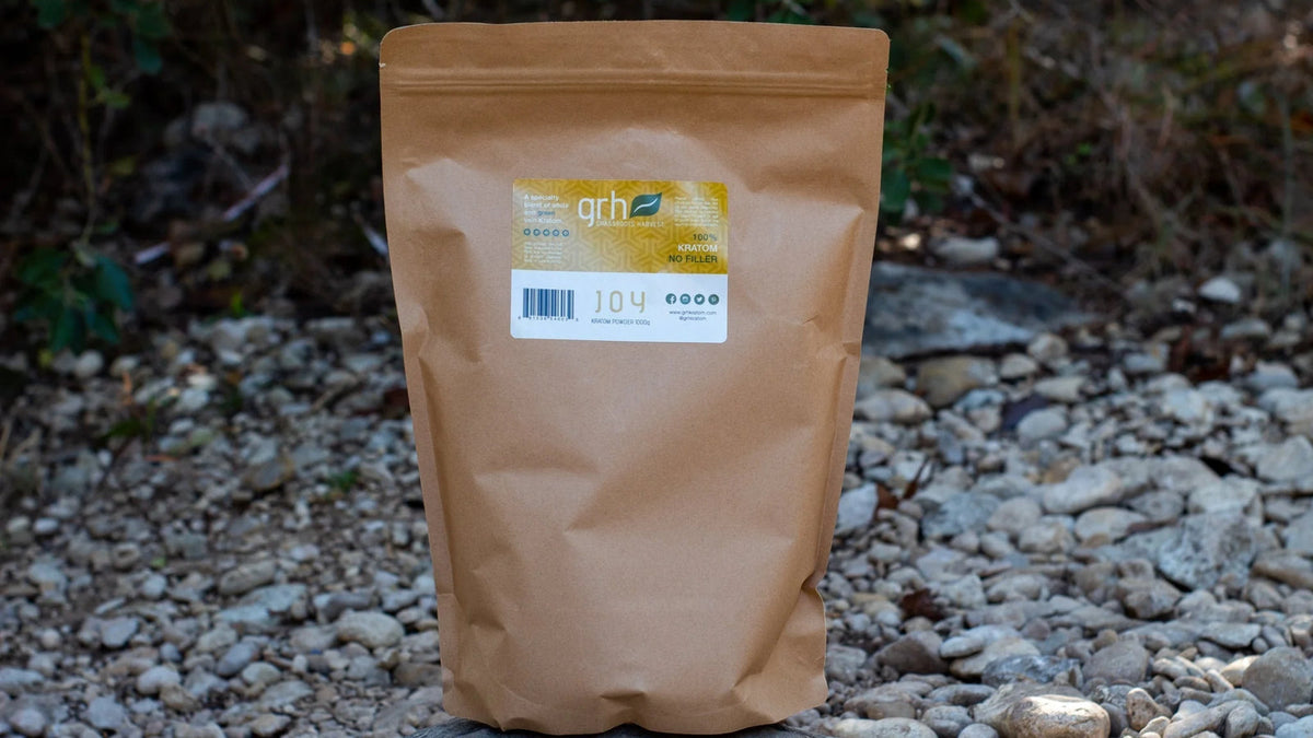 GRH Joy Blend kratom powder pouch and capsule bottle on a clean surface